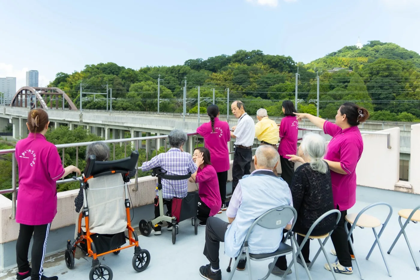 株式会社シルキーの屋上から景色を眺めるご利用者とスタッフ